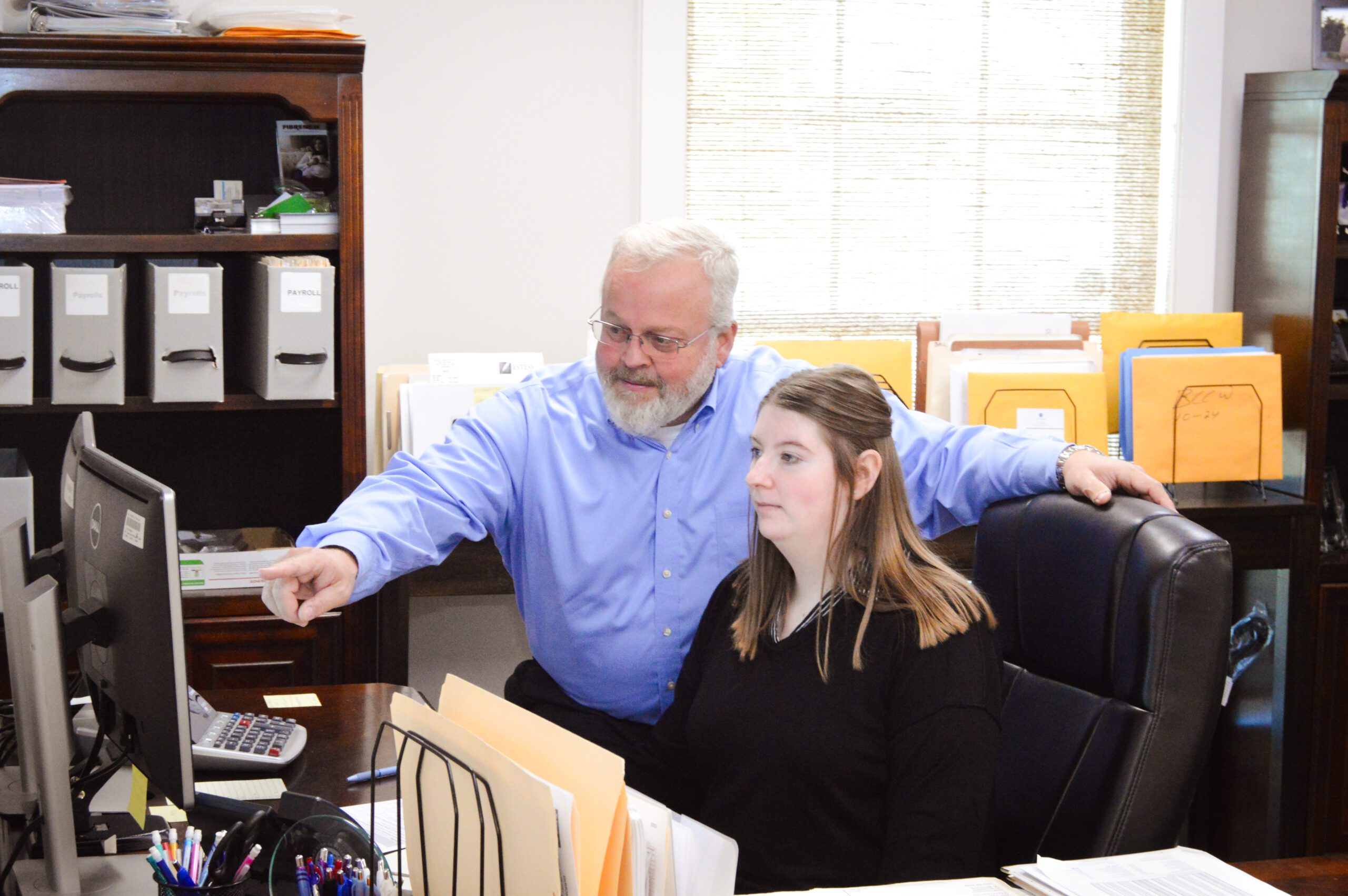 A man is signing documents while a woman observes attentively in a professional setting.